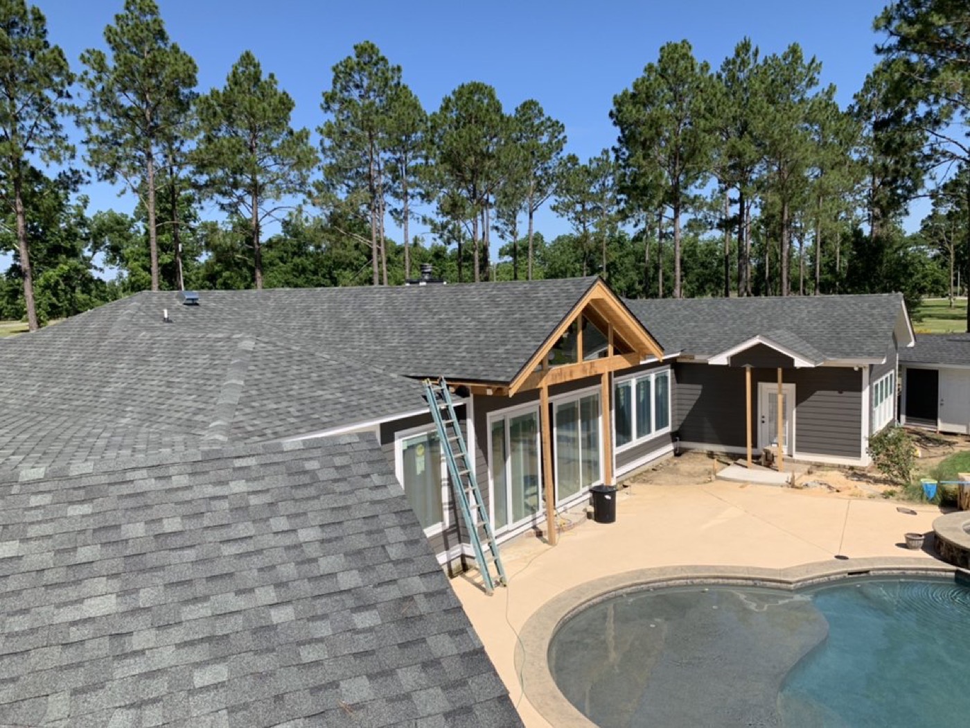 Aerial view of a shingle roof and a new wood-framed home addition